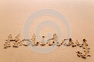 Holiday written in sand