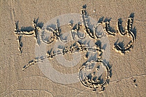 Holiday written in sand