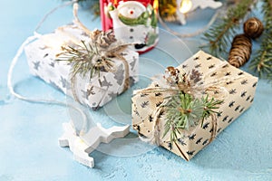 Holiday Xmas concept. Winter fir tree with present box, christmas lights and decor on a blue stone background for your greeting