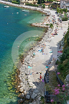 Holidaymakers on the beach of Malcesine on Lake Garda in Italy photographed from the tower of the Castello Scaligero