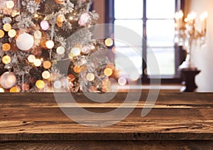 Holidays background with light spots, bokeh window and wooden tabletop