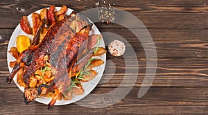 Holidays baked farm duck with apples, quince and spices on a dark vintage table.Top view with copy space of a baked duck for