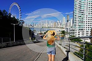 Holidays in Brazil. Back view of young woman enjoying Balneario Camboriu city skyline with Ferris Wheel, Santa Catarina, Brazil