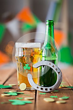 Glass of green beer, horseshoe and gold coins