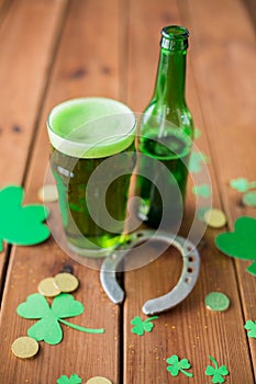 Glass of green beer, horseshoe and gold coins