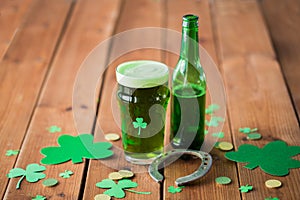 Glass of green beer, horseshoe and gold coins