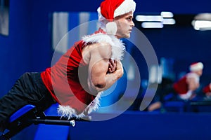 Holidays and celebrations, New year, Christmas, sports, bodybuilding, healthy lifestyle - Muscular handsome Santa