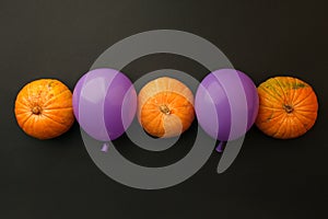 Holidays, decoration and party concept - pumpkins, air balloons for halloween over black background.