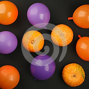 Holidays, decoration and party concept - pumpkins, air balloons for halloween over black background.