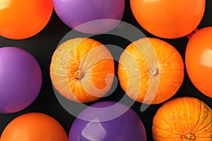 Holidays, decoration and party concept - pumpkins, air balloons for halloween over black background.