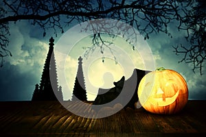Holidays halloween concept image. Pumpkin over wooden table and scarry night castle background