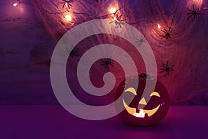 Holidays halloween concept image. Pumpkin, spiders over wooden table