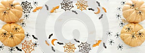 Holidays Halloween image. pumpkin, bats and spiders over wooden white table. top view, flat lay. banner