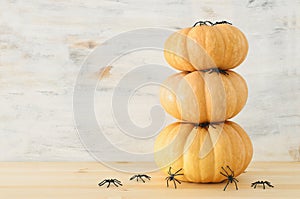 Holidays Halloween image. pumpkin and spiders over wooden white table