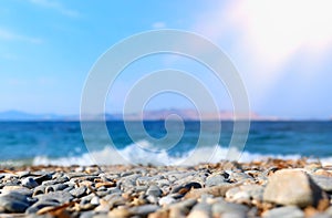 Holidays image of beach in front of summer sea with pebble stones background. selective focus