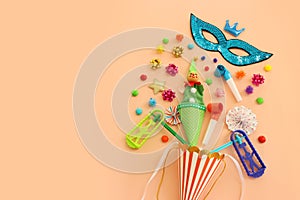 Holidays image of mardi gras masquarade mask and streamers over pastel background. view from above