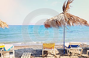 Holidays image of tropical sea and beach chairs under umbrellas. Summer travel and vacation concept