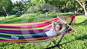 holidays. a little girl lies in a hammock.baby and hammock. summer. green garden