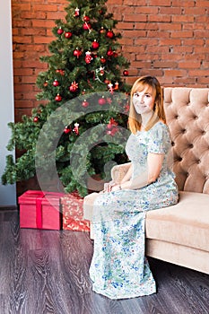 Holidays, x-mas, winter, happiness concept - smiling woman near the christmas tree