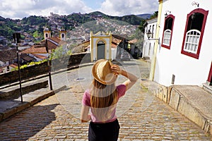 Holidays in Ouro Preto, Brazil. Back view of traveler woman descends street in the historic city of Ouro Preto, UNESCO World photo