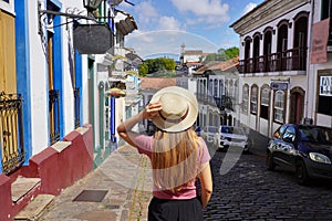 Holidays in Ouro Preto, Brazil. Rear view of tourist woman descends street in the historic city of Ouro Preto, UNESCO World