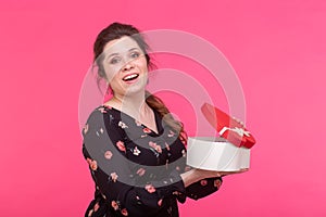 Holidays, present and surprise concept - Beauty happy girl with Valentine Gift box on pink background. Smiling surprised