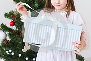 Holidays, presents, christmas, x-mas concept - close-up of child girl opens gift box.