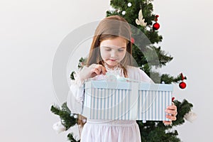 Holidays, presents, christmas, x-mas concept - happy child girl opens gift box.