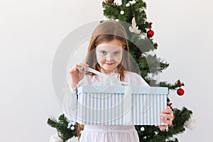 Holidays, presents, christmas, x-mas concept - happy child girl opens gift box.