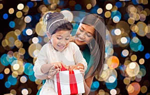 Happy mother and daughter girl with gift box