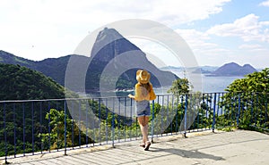 Holidays in Rio de Janeiro. Back view of traveler woman looking cable cars climbs from Urca Hill to Sugarloaf Mountain, UNESCO