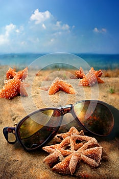 Holidays. sand beach, sunglasses and starfish
