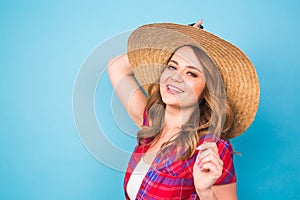 Holidays, summer, fashion and people concept - Girl in fashionable clothes straw hat. Portrait of charming woman on blue