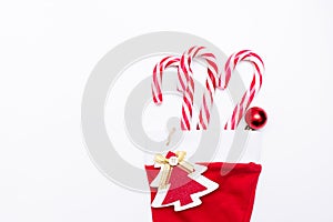 Holidays symbol stocking. Red christmas sock with gifts candy on a light background. Christmas background with copyspace