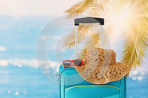 Holidays. travel concept. blue suitcase infront of tropical background photo