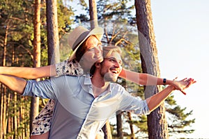 Holidays, vacation, love and friendship concept - smiling couple having fun over sky background.