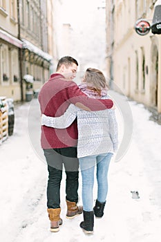 Holidays, winter, christmas, hot drinks and people concept - happy couple in warm clothes having fun, hugging in winter