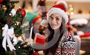 Holidays, winter and people concept - young woman in Santa hat b