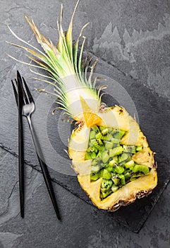 Holidey diet concept or tropical Christmas menu concept. Christmas tree made from pineapple and kiwi on slate board
