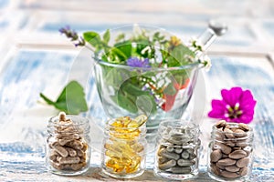 Holistic medicine approach. Healthy food eating, dietary supplements, healing herbs and flowers. wooden background, c. photo