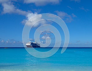 The Holland America Line Zuiderdam cruise ship anchored off the private island of Half Moon Cay in the Bahamas on a sunny day with
