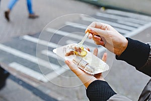 Holland herring fish in female hand outside. Traditional Dutch street food, herring fish. Stock photo street food, herring fish