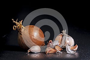 Holland Onions and galic on a black background.