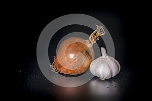 Holland Onions and galic on a black background with low light..