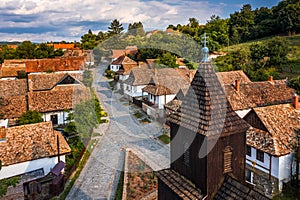 Holloko, Hungary - Aerial view of the tower of the traditional catholic church of Holloko at the village centre on a summer day photo