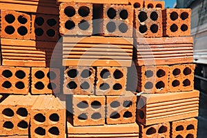 Hollow red bricks piled in a pile, ready for use in construction or for sale. Construction material