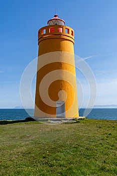 Holmsberg Lighthouse, an orange light house on the Reykjanes Peninsula in Iceland