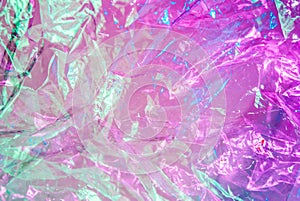 Holographic background in the style of the 80-90s. Real texture of cellophane film in bright acid colors.