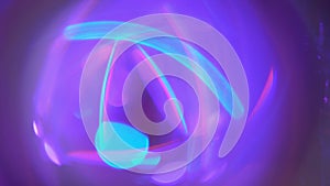 A holographic iridescent unicorn pastel purple pink teal blue colors lights abstract background. Hypnotic ring rotation