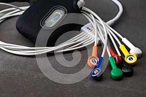 Holter, medical device for a heart rate measurement with all the colorful cables on industrial gray background